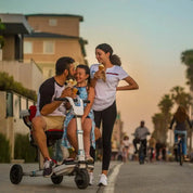 Family eating ice cream around the Moving Life ATTO Sport scooter at sunset.